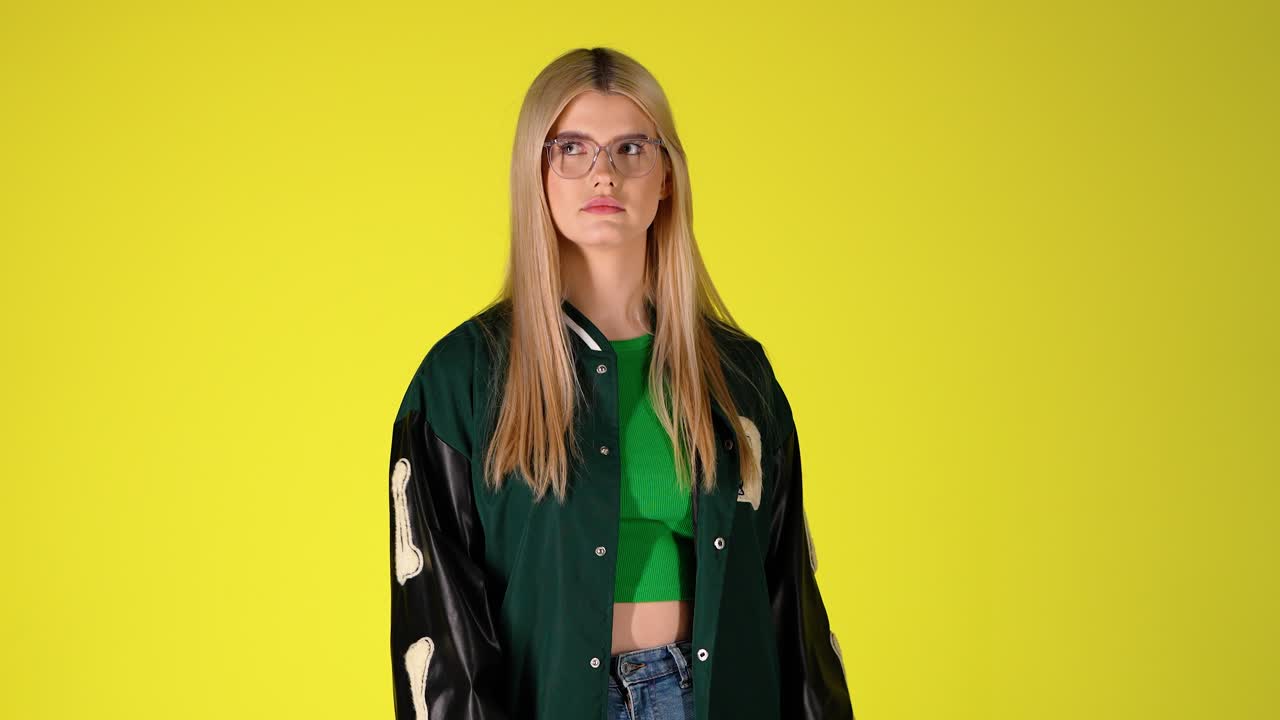 Studentessa bionda che legge documenti, comportamento frustrato ed esasperato, scatto in studio colorato.