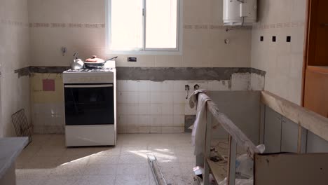 gas range with kettle and pan in an unfinished kitchen, slider right