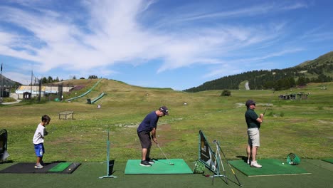 two people practicing golf in a scenic location