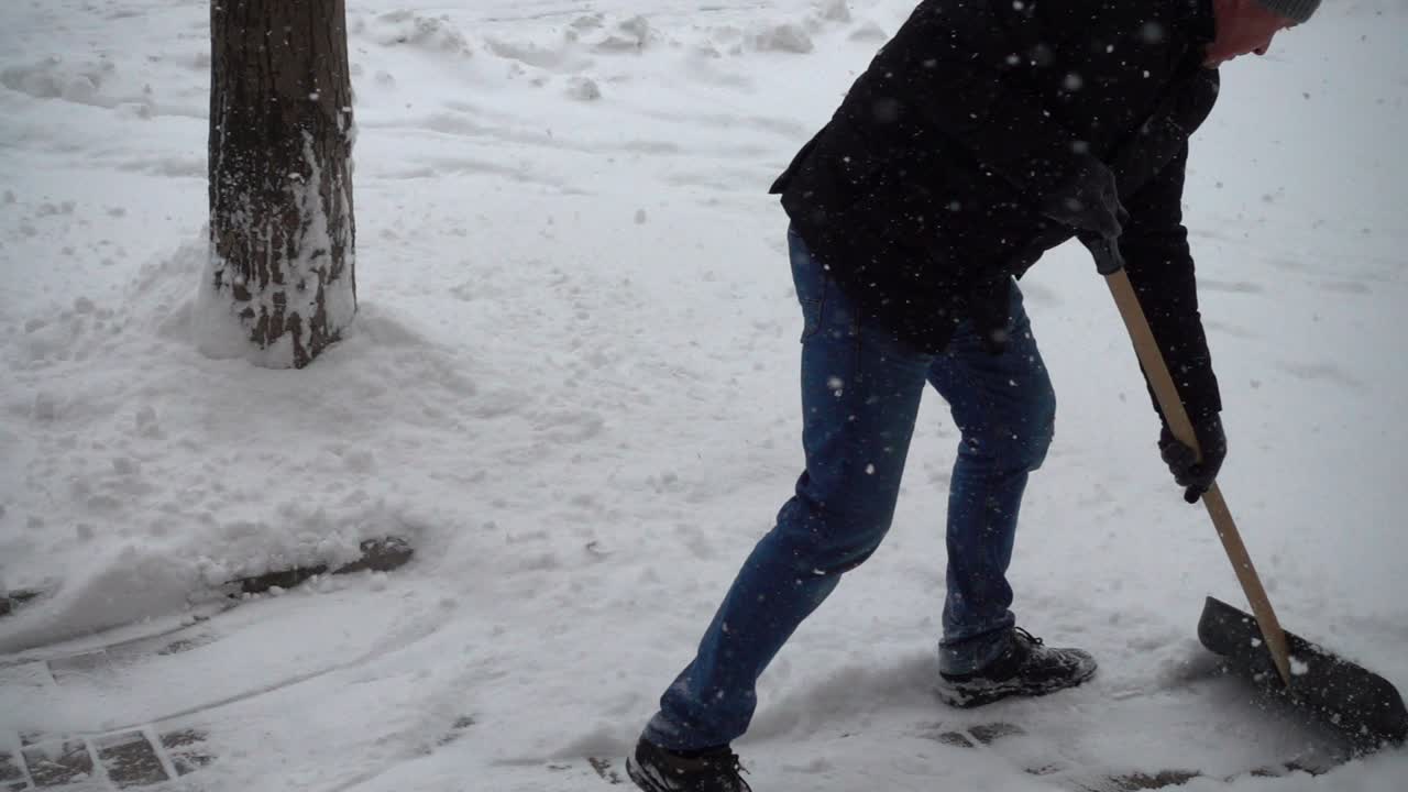 Den ukendte mand renser gaden for sne. Slowmotion