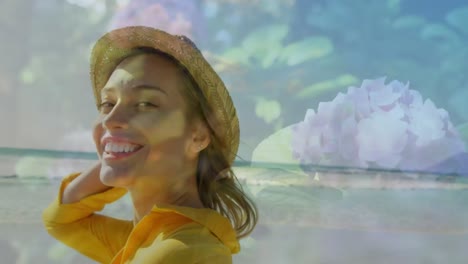 composite video of portrait of caucasian woman wearing a hat smiling against flower in the garden