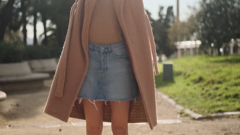 une jeune femme debout et posant dans le parc.