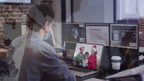 Animation-of-caucasian-man-in-face-mask-having-video-call-with-family-in-office