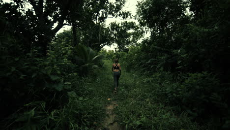woman hiking through a lush tropical forest