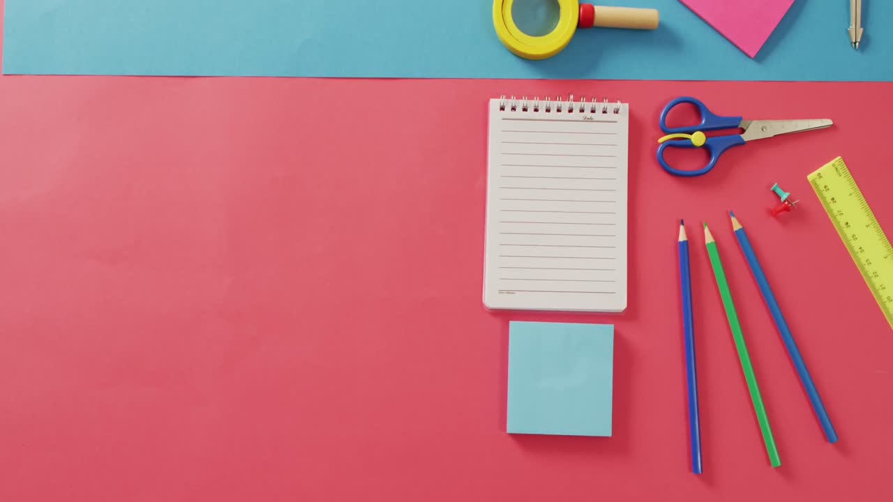 video de un cuaderno con espacio para copiar y artículos escolares en fondo rosa y azul