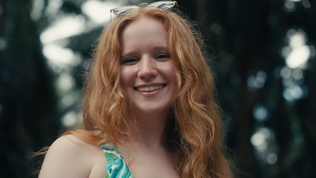 Red-haired woman smiling outdoors