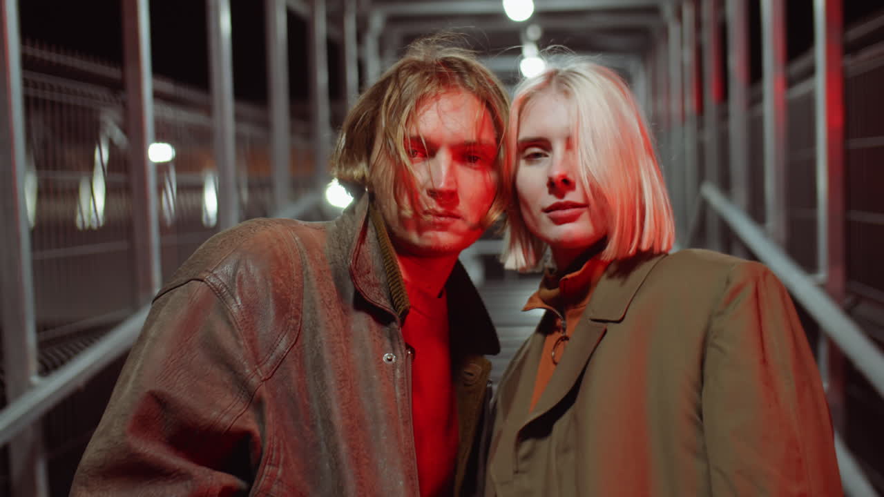 retrato de una pareja romántica en un puente peatonal por la noche