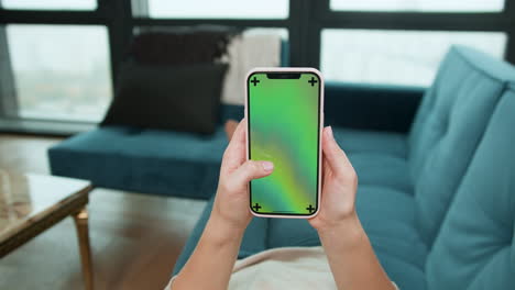 woman scrolling on smartphone at home