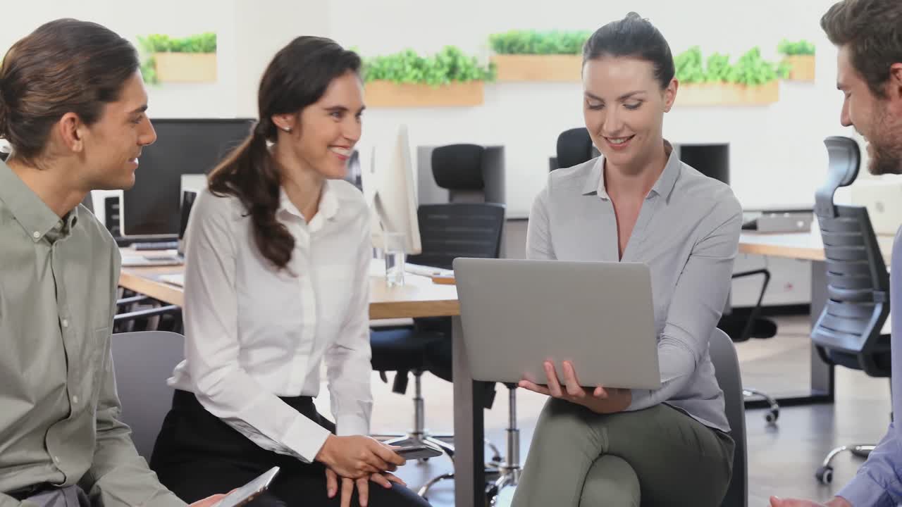 colegas de negocios discutiendo sobre una computadora portátil 4k