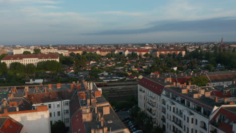 Vorwärts-Fliegen-über-Städtische-Nachbarschaft.-Luftaufnahme-Des-Zugfahrens-Auf-Der-Bahnstrecke.-Szene-Beleuchtet-Von-Hellem-Morgensonnenschein.-Berlin,-Deutschland