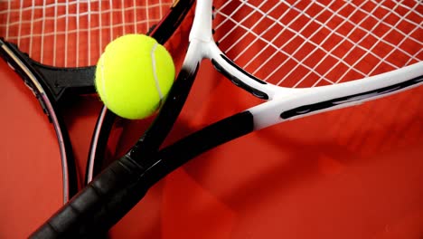 close-up of tennis ball and rackets on red floor 4k