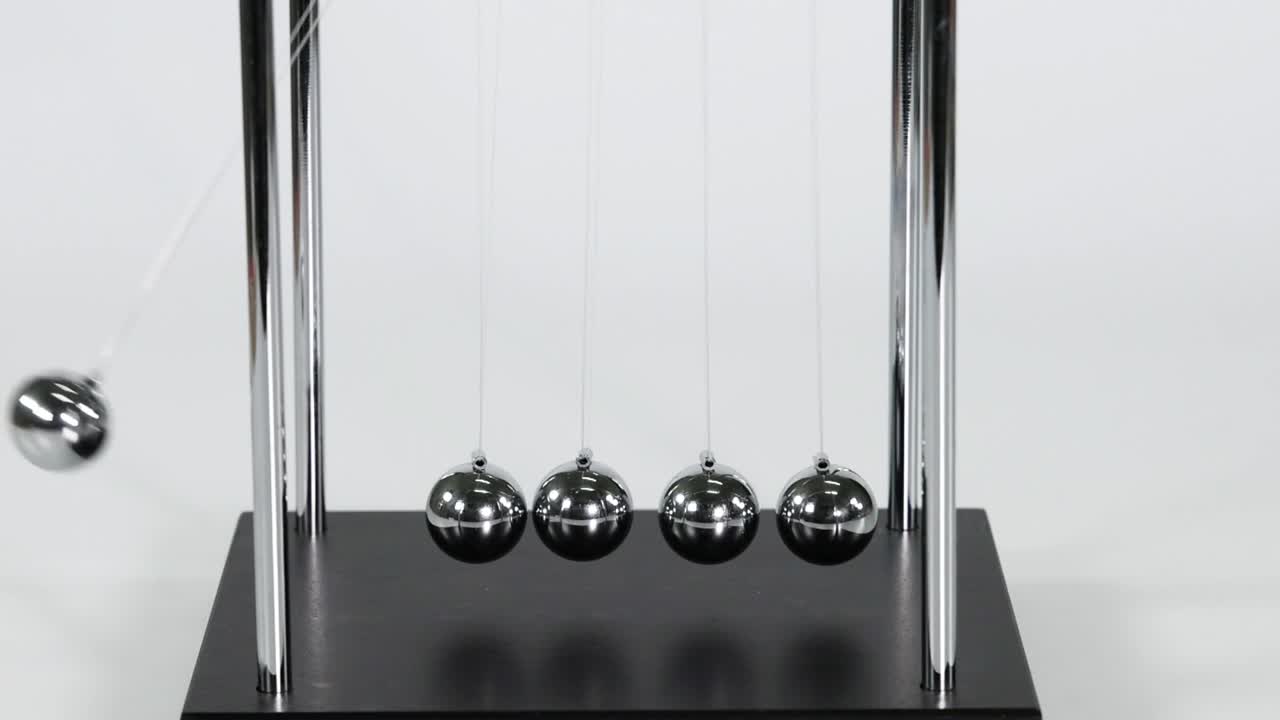 Detailed view of a single ball impacting and transferring motion in a Newton's Cradle.