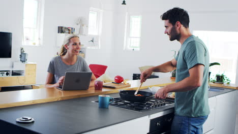 una joven pareja preparando comida juntos en una cocina moderna