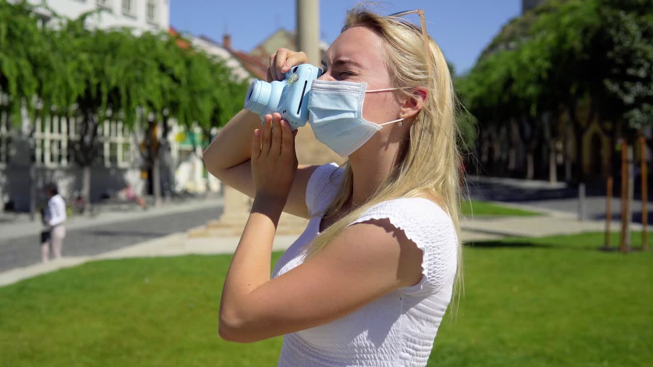 covid-19 젊은 아름다운 금발 십대 관광 여성은 휴가에 폴라로이드 카메라로 사진을 찍습니다