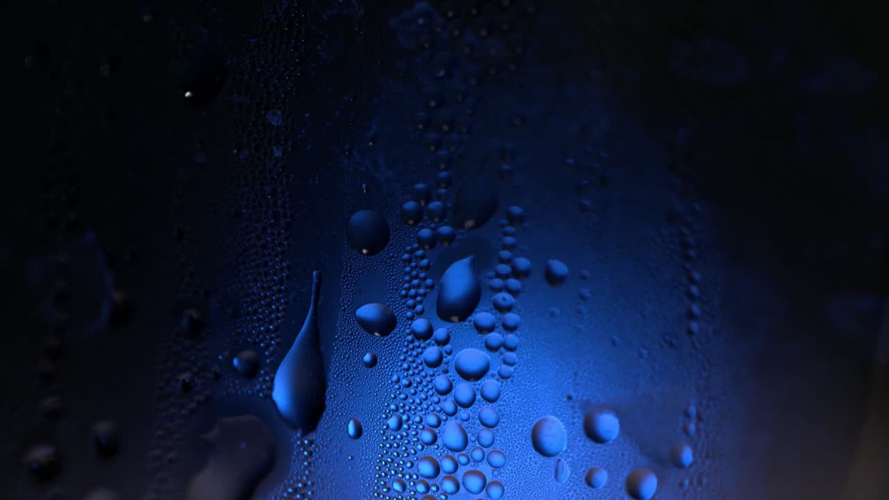 gotas de agua en vidrio con luz azul