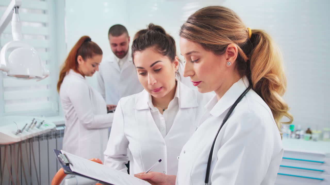 Doctors in the dental office. Talking nurses and one noting doctor