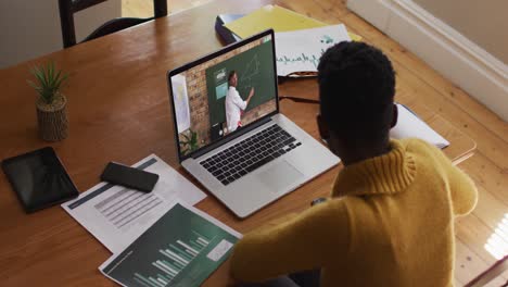 african american female student using laptop on video call with male teacher