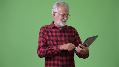 hombre de barba viejo y guapo contra un fondo verde.
