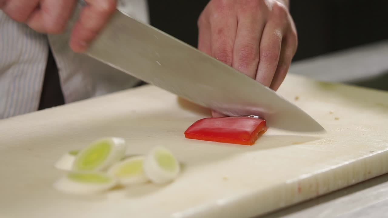 chef cortando pimienta roja y puré