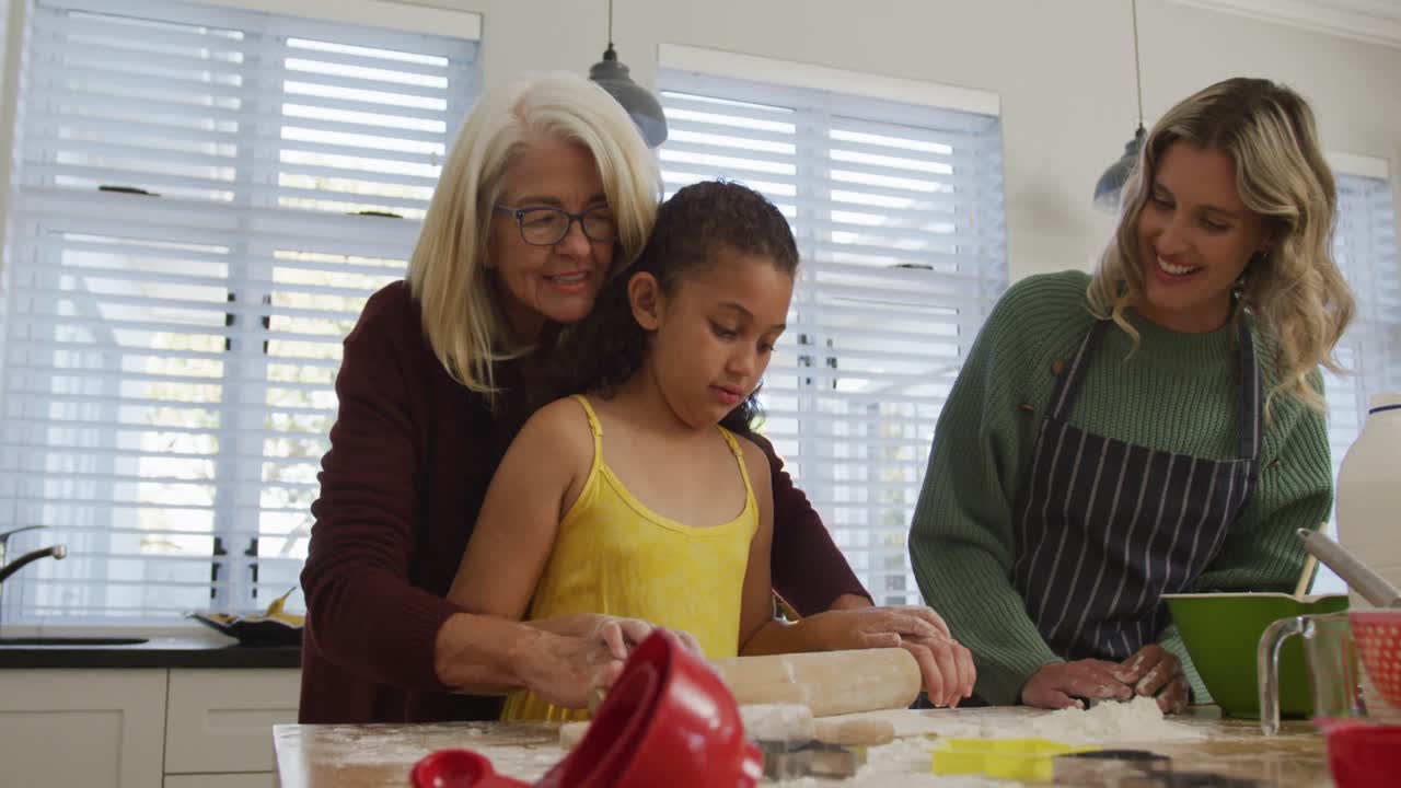 Video of happy diverse family cooking together in the kitchen
