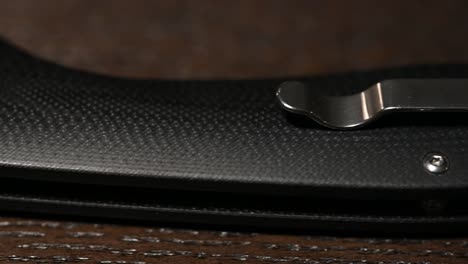 slide over a high-end tactical folding knife with composite handle, thumb opener and ball bearing pivot, and pocket clip, sliding right to left