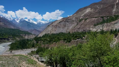 toma aérea de las montañas hunza sobre el río indo, la ciudad verde y el cielo azul con nubes