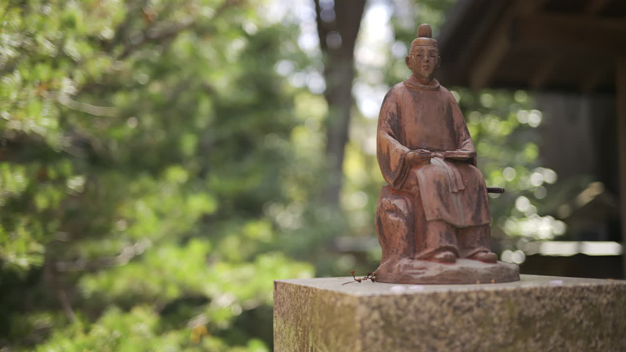 A detailed look at a bronze statue representing a historical figure, situated in Fushimi Inari, Japan, Kyoto
