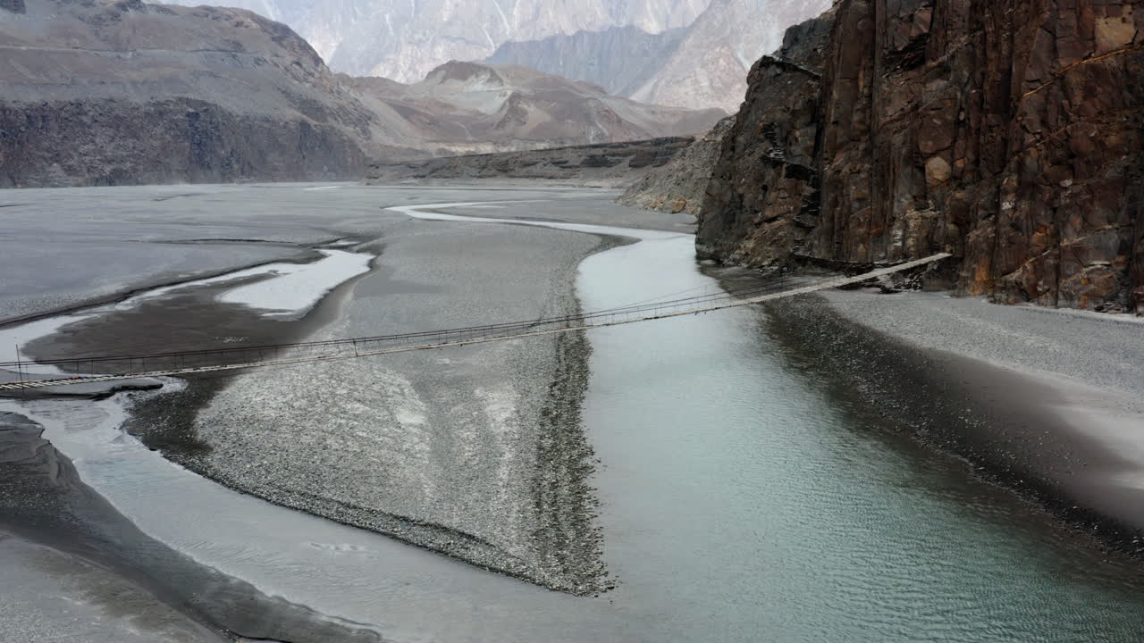 puente colgante hussaini sobre el río hunza, gilgit baltistán, norte de pakistán - toma aérea de drones