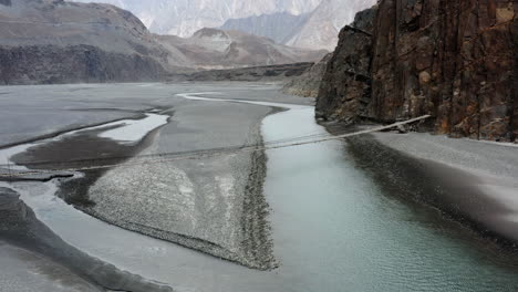 hussaini suspension bridge over hunza river, gilgit baltistan, northern pakistan - aerial drone shot