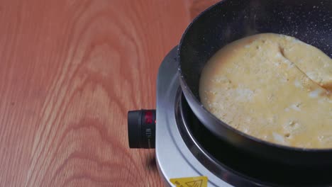 Closeup-of-frying-pan-with-pancake-in-the-making,-flipped-over