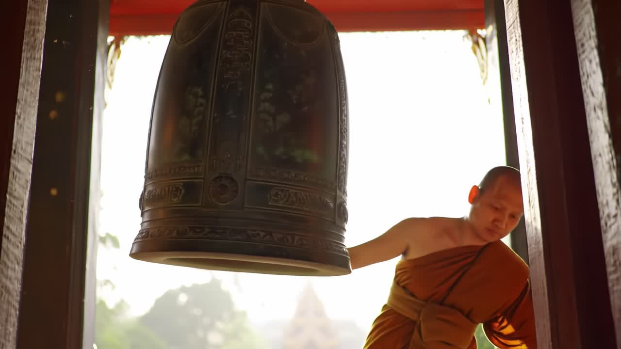 A Monastic Ritual: Serenity and Tradition Captured in the Graceful Motion of a Monk Ringing a Large Bell at Sunset in a Peaceful Temple Setting