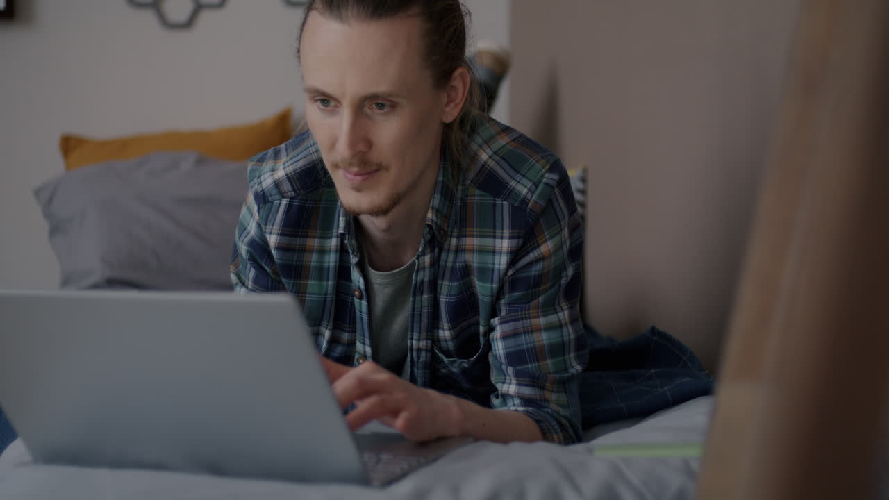 hombre trabajando en la computadora portátil en la cama