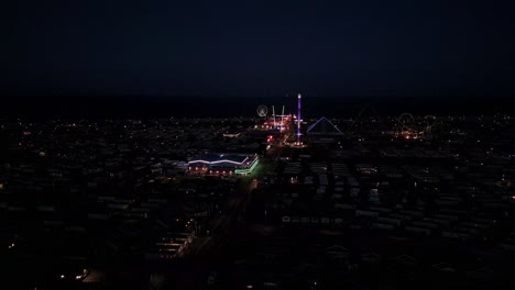 dusk, aerial footage of a typical seaside amusement park. fantasy island amusement park at night in the seaside town of ingoldmells near skegness