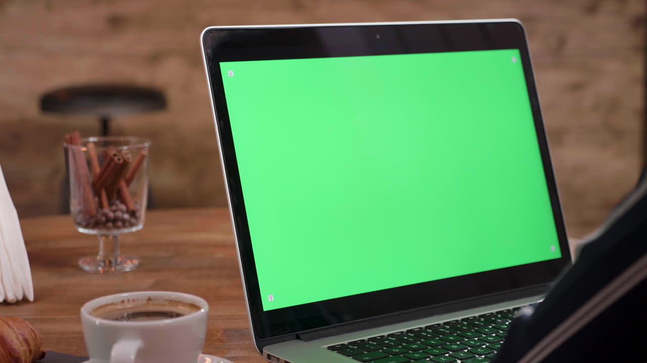 Laptop with green screen and coffee