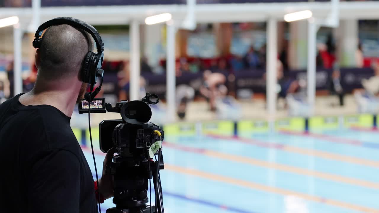 카메라맨 은 수영 대회 중 운동 선수 들 을 촬영 한다