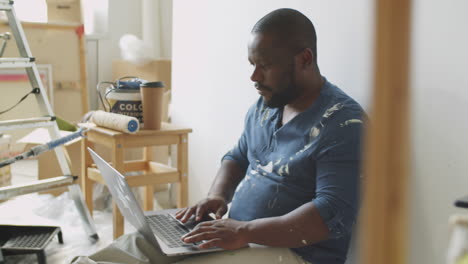 man working on laptop in a construction site