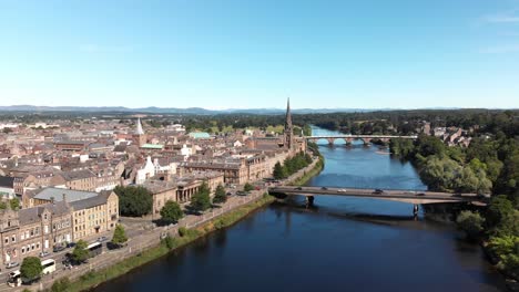 Drone-Volando-Sobre-El-Río-Tay-Revelando-La-Hermosa-Ciudad-De-Perth-Y-Las-Tierras-Altas-Escocesas-En-La-Distancia