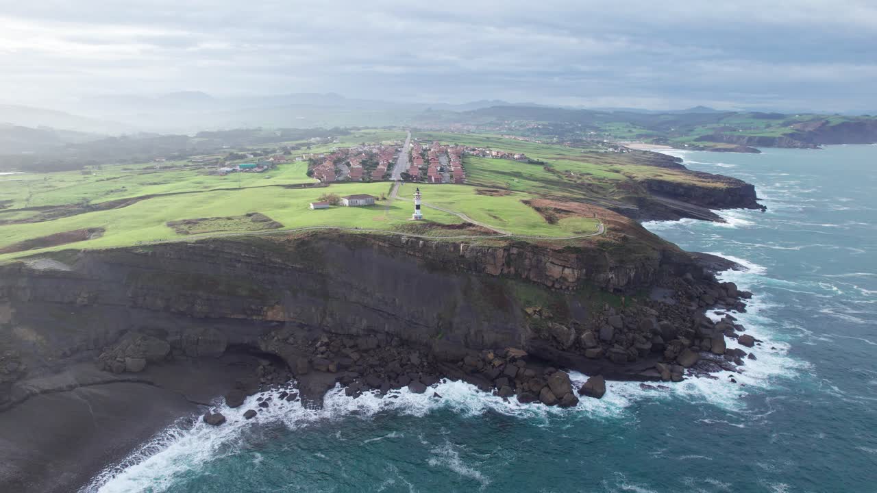 tiro hacia atrás desde un faro colorido único hacia el mar azul abierto, ajo, españa