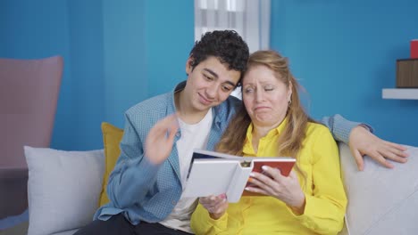 The-young-man-and-his-mother-are-looking-at-the-photo-album-together.