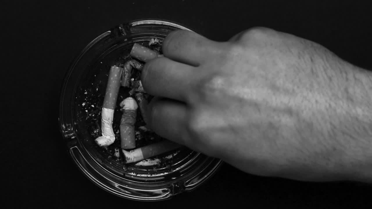 cigarrillo quemándose en el cenicero y siendo apagado