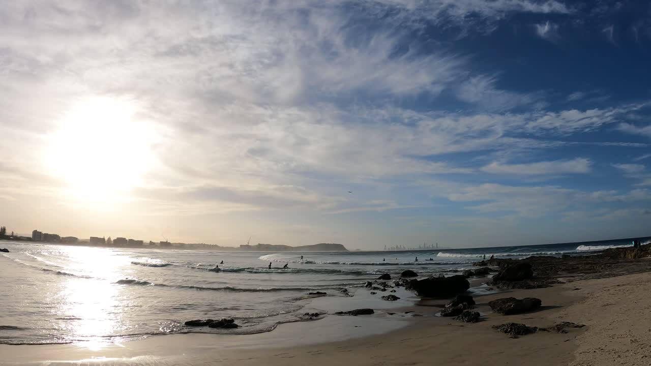 파도, 서퍼, 그리고 커럼빈 해변에서 해가 지는 모습