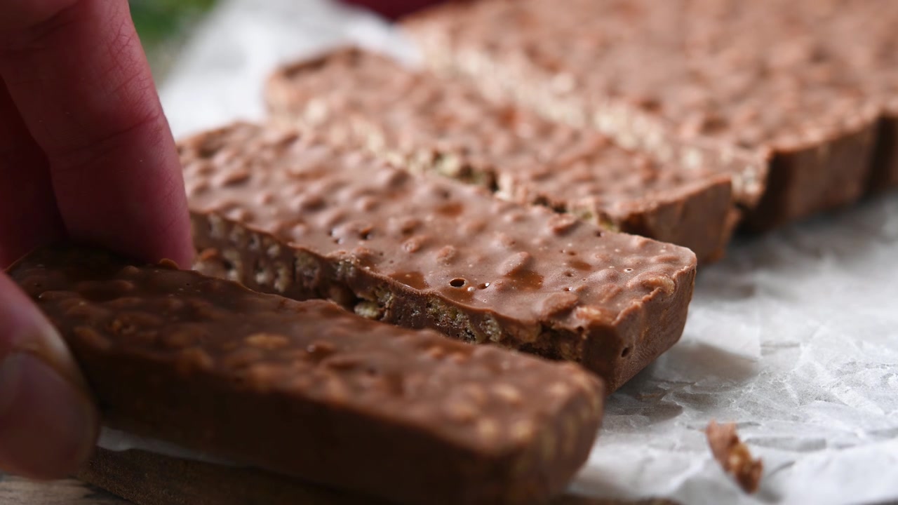 Scegliere a mano una barretta di torrone al cioccolato, dolce tradizionale natalizio