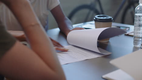 diverse jonge zakenmensen ondertekenen een contract, een deal, een vrouwelijke ondernemer schrijft een handtekening op een juridisch document, geniet van een zakelijke partnerschapsvergadering in een modern kantoor