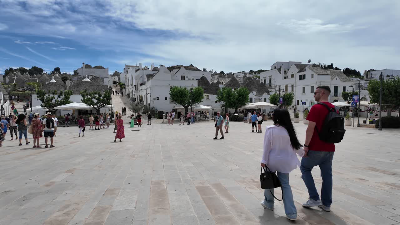Charming Square in Alberobello, Encircled by White Houses, Tourists, and Shops, in Bari Province, Apulia Region, Italy
