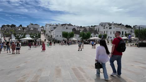 charming square in alberobello, encircled by white houses, tourists, and shops, in bari province, apulia region, italy