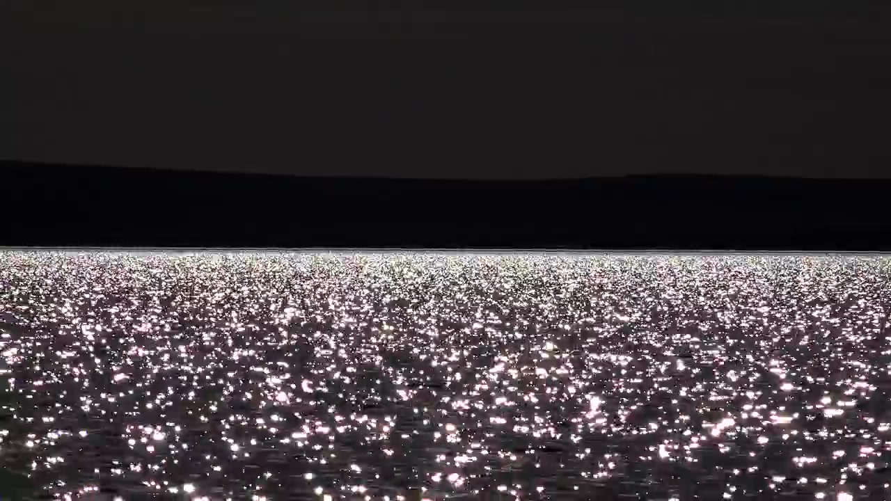Sollys glitrer på overfladen af en rolig sø