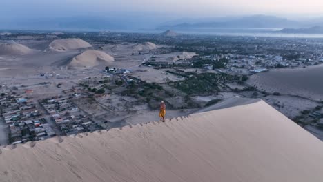 mujer caminando por una duna de arena