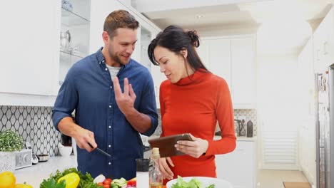 Couple-cutting-vegetables-in-kitchen-at-home-4k