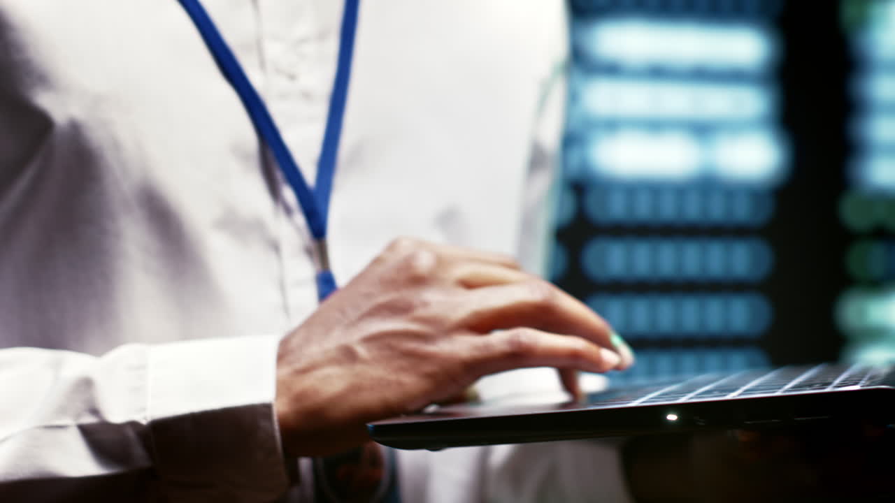 Developer using laptop to examine server