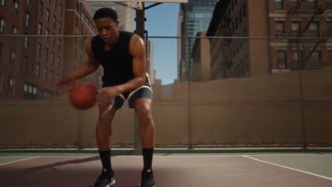 young man dribbling a basketball on an urban court